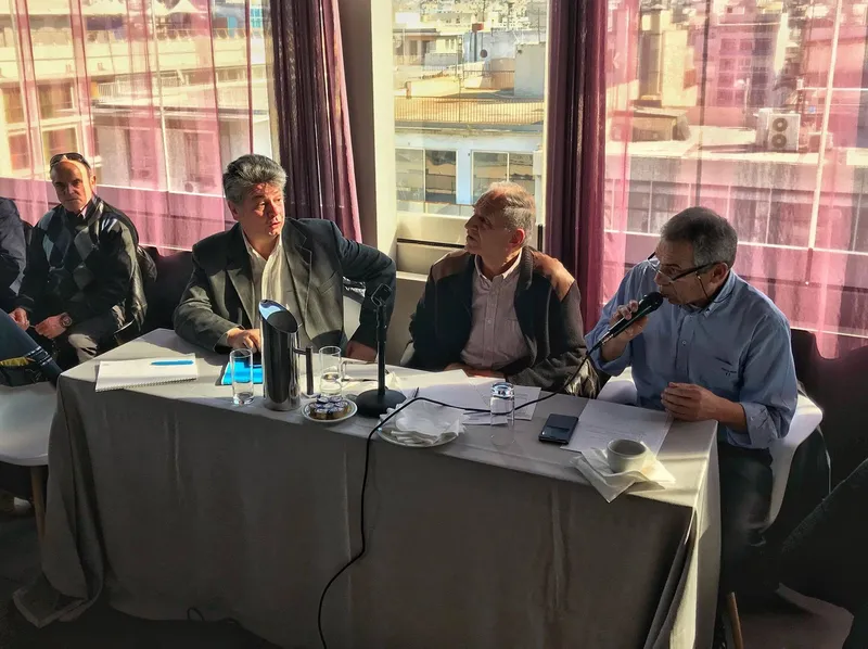 Το Διοικητικό Συμβούλιο σε τραπέζι συνεδρίασης στη Γενική Συνέλευση, με θέα στις ταράτσες της Αθήνας